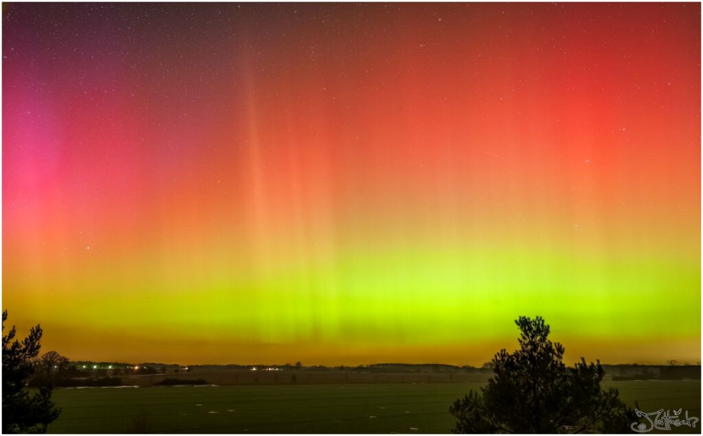 Bunte Polarlichter über Feldern